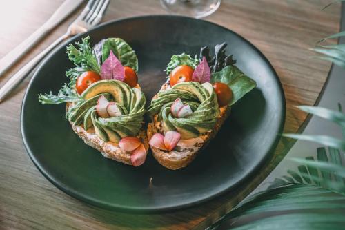 a plate with two slices of bread with vegetables on it at Crowne Plaza Merida by IHG in Mérida