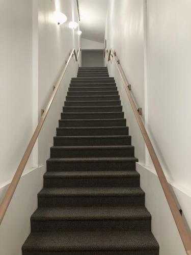 a staircase in a building with grey stairs at Annapurna - Meredith Lodging in Leavenworth