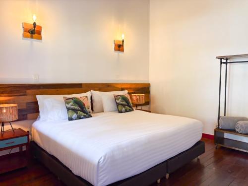 a bedroom with a white bed with two lights on the wall at Dreamer Cocora in Salento