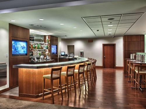 a bar in a restaurant with wooden floors and chairs at InterContinental Suites Hotel Cleveland by IHG in Cleveland