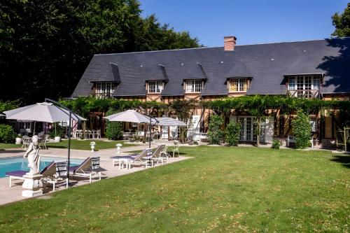 une grande maison avec une piscine et une cour dans l'établissement Domaine De La Boissière, à Trouville-la-Haule