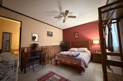 a bedroom with a bed and a desk and a ceiling fan at West Refugio in San Juan del Río