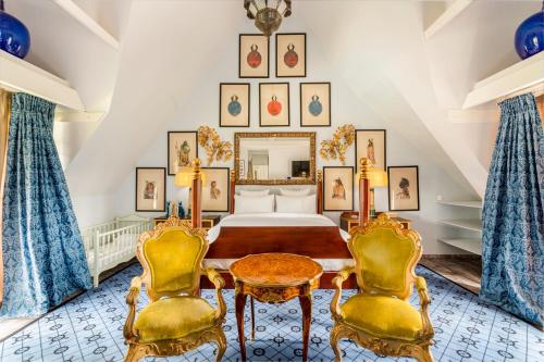 une chambre avec un lit et deux chaises dans l'établissement Domaine De La Boissière, à Trouville-la-Haule