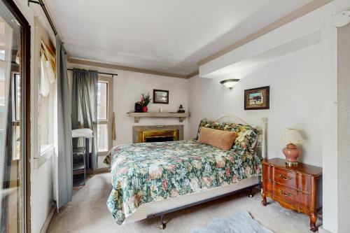 una camera con letto, tavolo e camino di Saddle Road Condo a Bijou Park