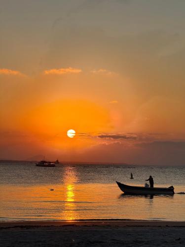 a man in a boat on the beach at sunset at Recanto do Sol in Paranaguá