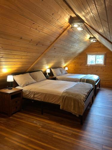 two beds in a room with a attic at Amphitheater Mountain Cabin in Silver Gate