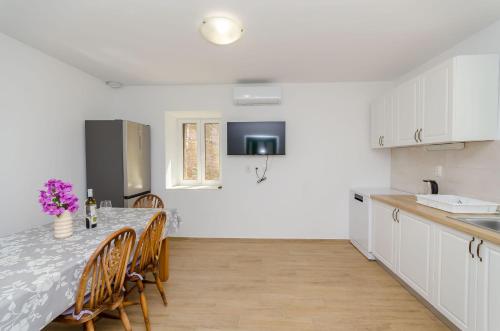 a kitchen and dining room with a table and chairs at House Mateljan in Poljica