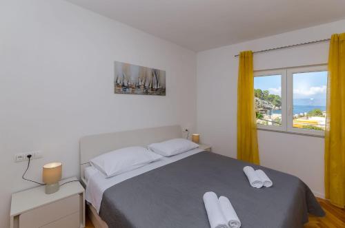 a bedroom with a bed with white towels on it at House Mateljan in Poljica
