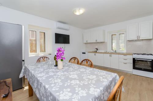 a kitchen with a table with purple flowers on it at House Mateljan in Poljica