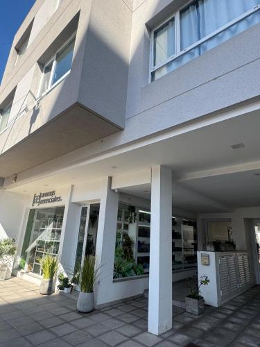 a white building with potted plants in front of it at Departamentos Apart PM in Necochea