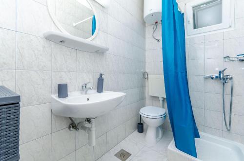 a bathroom with a sink and a toilet and a mirror at House Mateljan in Poljica