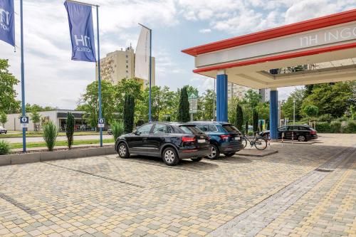 two cars are parked at a gas station at NH Ingolstadt in Ingolstadt