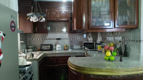 a kitchen with wooden cabinets and a granite counter top at Recidencial sharael house in San Isidro