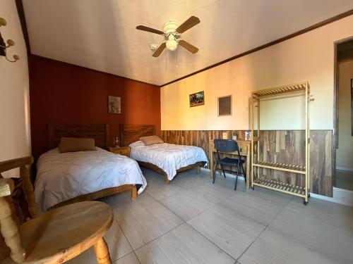 a bedroom with two beds and a ceiling fan at West Refugio in San Juan del Río