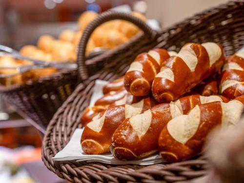 a basket filled with pastries on top of a table at Mövenpick Hotel München-Airport in Hallbergmoos