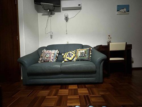 a blue couch in a living room with pillows on it at Campinho Café Alojamento Local in Fátima