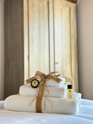 a stack of towels with a candle on a bed at Under The Tuscan Sun in Arezzo