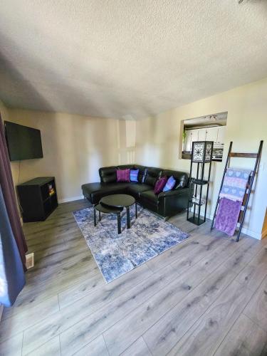 a living room with a black couch and a table at The Onyx Suite In Inglewood Minutes To DT in Calgary
