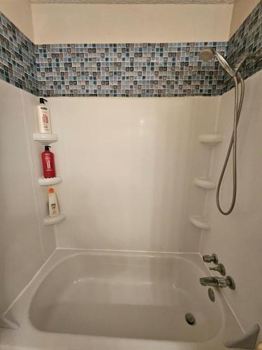 a white bath tub in a bathroom with a shower at The Onyx Suite In Inglewood Minutes To DT in Calgary