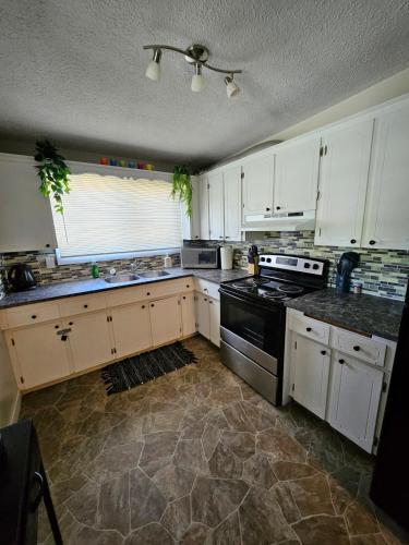 a kitchen with white cabinets and a stove top oven at The Onyx Suite In Inglewood Minutes To DT in Calgary