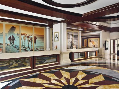 ドバイにあるMövenpick Hotel & Apartments Bur Dubaiの壁に大きな絵が飾られたロビー