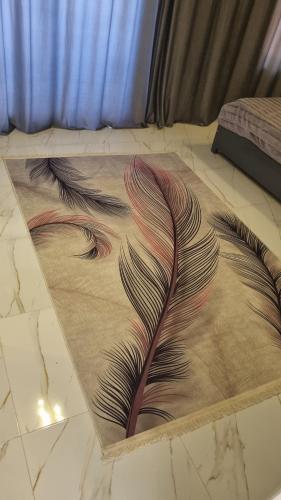 a rug with peacock feathers on a bed at Villa Saeed in Al Karnak