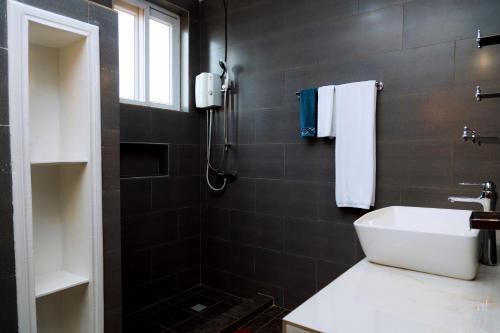 a bathroom with a white sink and a shower at Million views kigali in Kigali