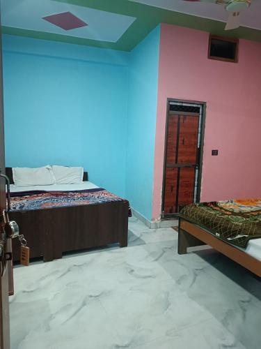 una camera con un letto e una parete rosa e blu di Chandrika Palace Agnikund Near RAM MANDIR a Ayodhya