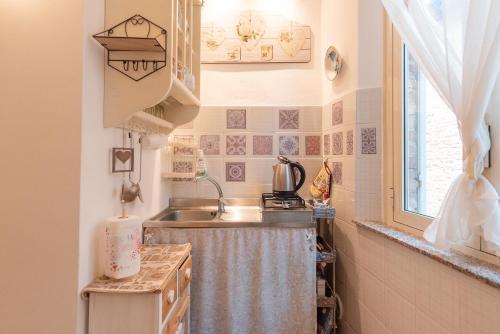 a small kitchen with a sink and a window at Il Nido del Vicolo delle scuole Pie in Città della Pieve