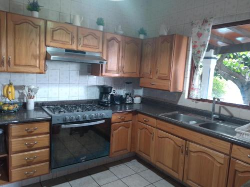 a kitchen with wooden cabinets and a stove top oven at La Super Casa en Palmira in Cuernavaca