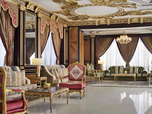 a living room filled with furniture and a chandelier at Mövenpick Hotel City Star Jeddah in Jeddah