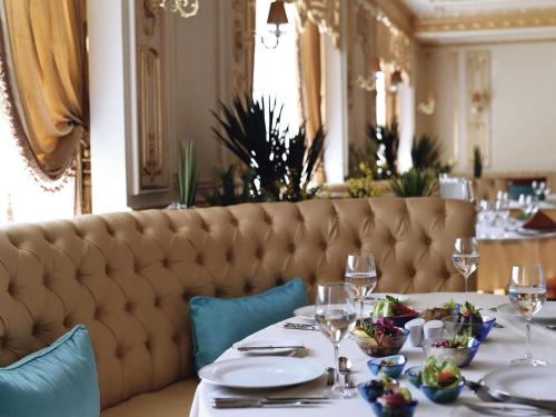 a dining room with a table with plates and wine glasses at Mövenpick Hotel City Star Jeddah in Jeddah