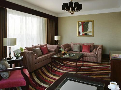 a living room with two couches and a table at Mövenpick Hotel City Star Jeddah in Jeddah