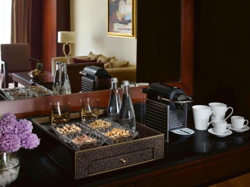 a table with a tray of food and drinks at Mövenpick Hotel City Star Jeddah in Jeddah