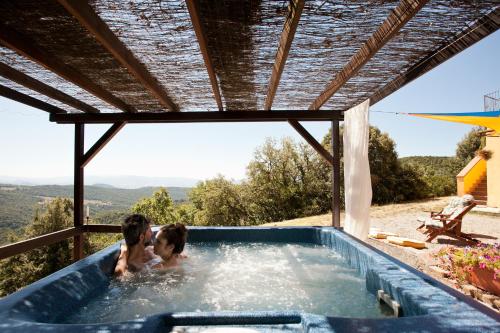 two people in a jacuzzi in a swimming pool at Casale Pundarika in Riparbella