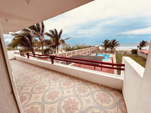 un balcon avec vue sur une piscine et l'océan dans l'établissement Casa Playa Blanca, a private beach home, à Ixtapa-Zihuatanejo International