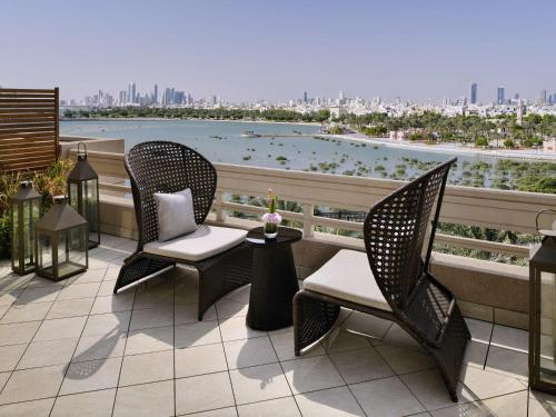 a balcony with chairs and a view of the water at Mövenpick Hotel Bahrain in Manama