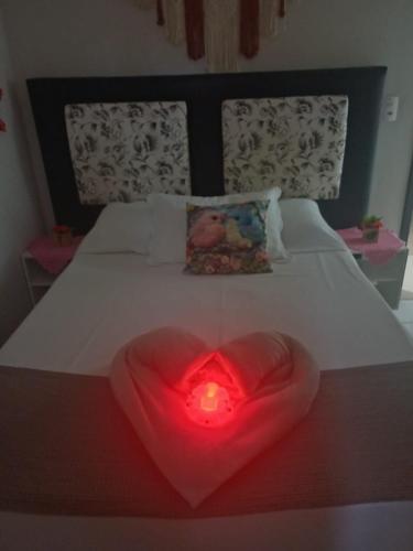 a heart shaped light on a bed with a candle at Harmonia Haus in Blumenau