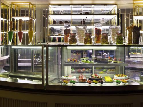 a display case filled with lots of different desserts at Mövenpick Hotel Bahrain in Manama