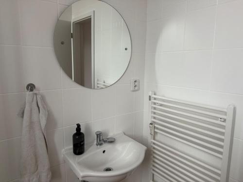 a white bathroom with a sink and a mirror at Apartmán až pro 3 osoby in Humpolec