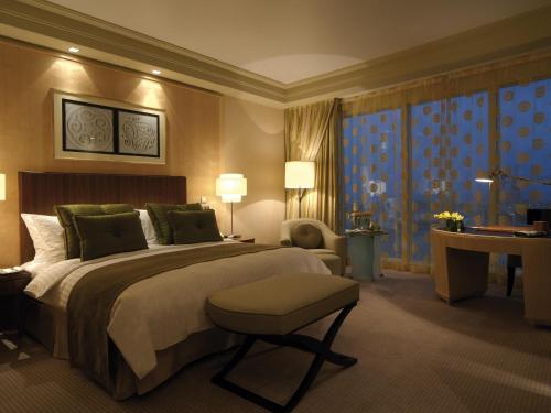 a hotel room with a large bed and a desk at Mövenpick Hotel Al Khobar in Al Khobar