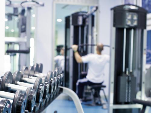 two men in a gym exercising in machines at Mövenpick Hotel Al Khobar in Al Khobar