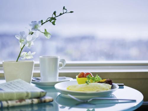 a table with a plate of food and a cup of coffee at Mövenpick Hotel Al Khobar in Al Khobar