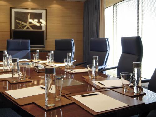 a conference room with a large wooden table and chairs at Mövenpick Hotel Al Khobar in Al Khobar
