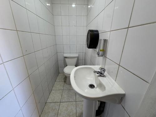 a white bathroom with a toilet and a sink at Residencial Don Santiago in Talca