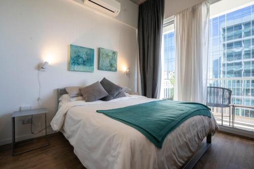 een slaapkamer met een groot bed en een groot raam bij Distrito Quartier Retiro in Buenos Aires