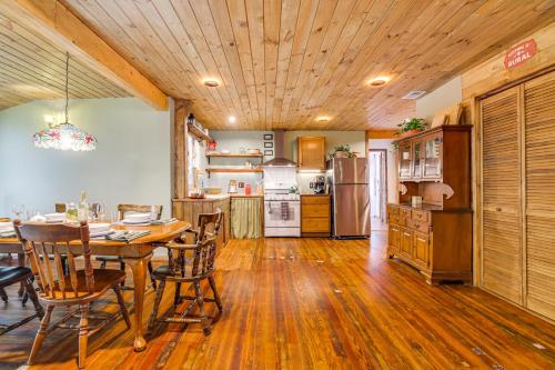 a kitchen with a dining room table and a refrigerator at Ski, Swim, Relax Old-Fashioned Poconos Getaway in Pocono Pines