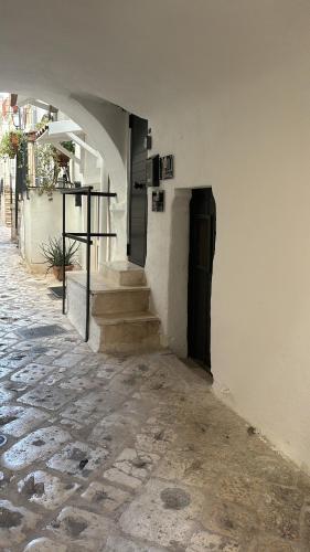an alley with a door and stairs in a building at Dimore Levante - La Dimora nel borgo in Turi