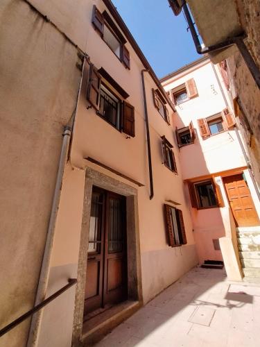 an alley in an old building with a wooden door at Casa Petracca in Muggia