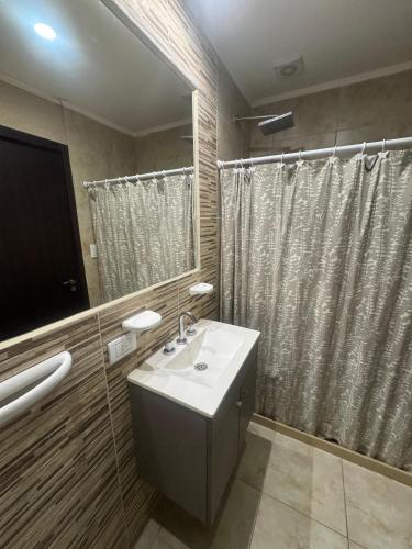 a bathroom with a sink and a large mirror at Apart Pm Casa de playa in Necochea